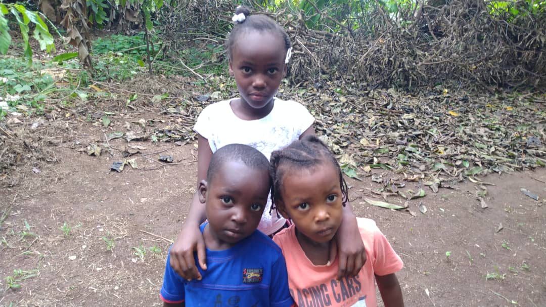 Three Children Standing on a Dirt Path