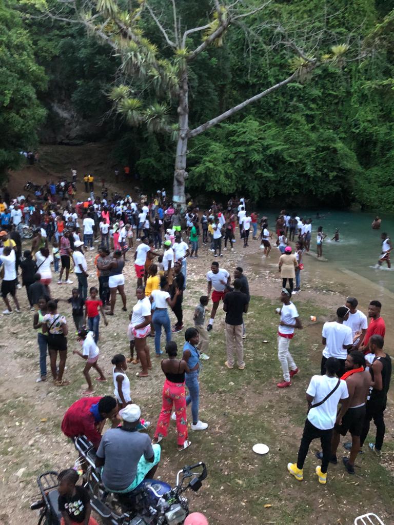 Crowd Gathered at a Riverside Clearing